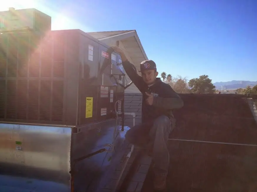 HVAC technician performing Air Duct Cleaning on a rooftop unit in Idabel